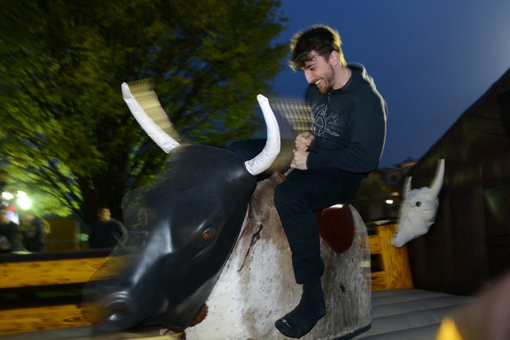 college student riding a mechanical bull