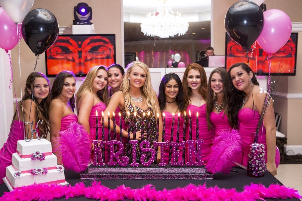 sweet 16 girl surrounded by her friends in hot pink dresses
