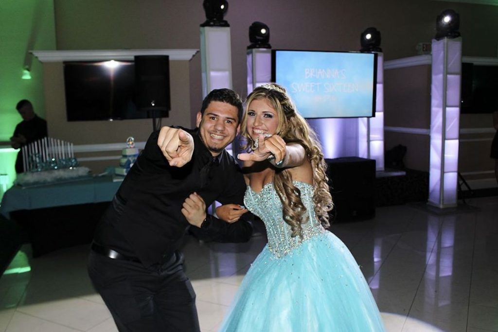 girl at her sweet 16 posing with pisp mc pointing at the camera