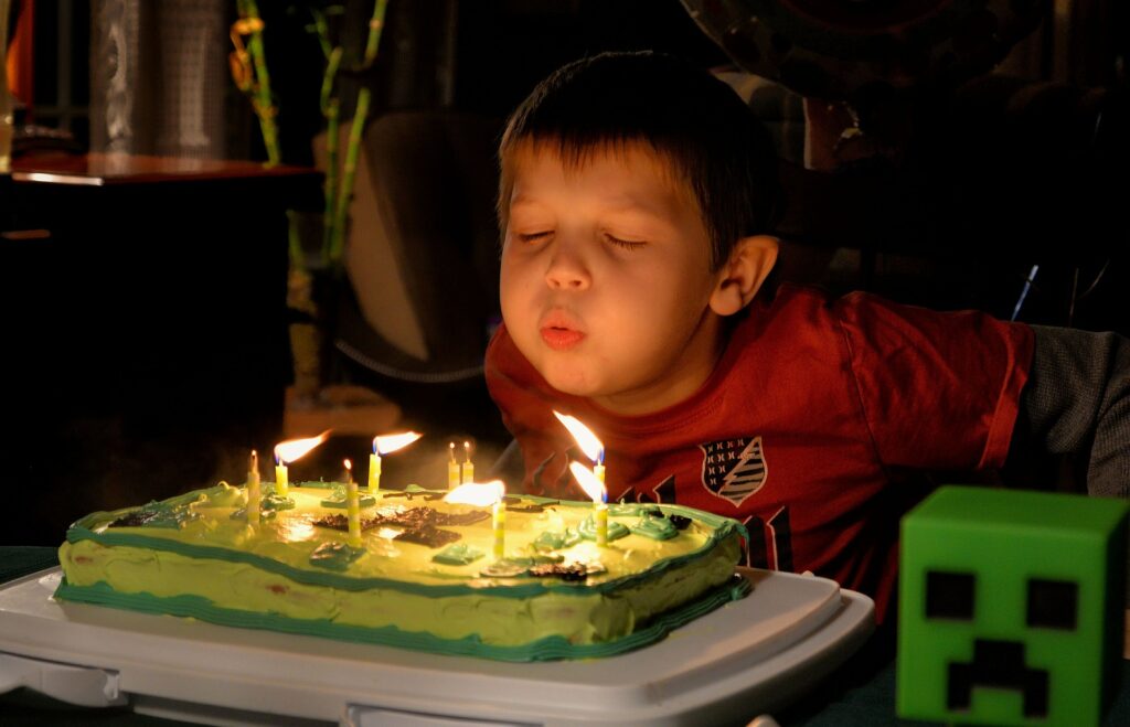 boy blowing out birthday candles